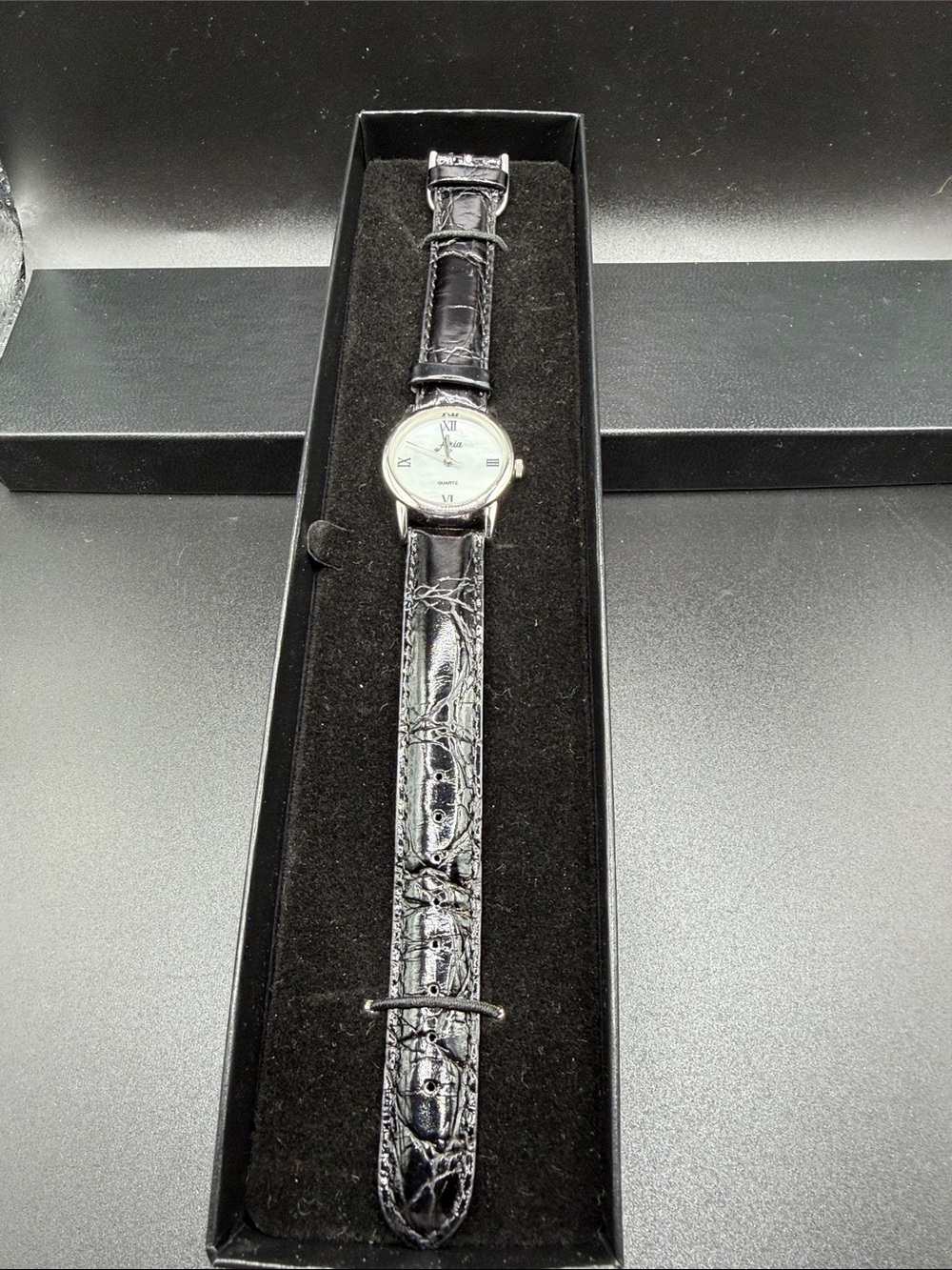 Aria quartz watch with leather strap. New in box but needs new battery.